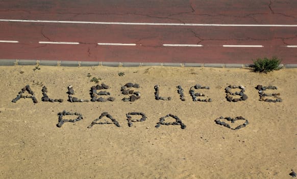 All love dad, a lettering laid out of stones for dad's birthday.