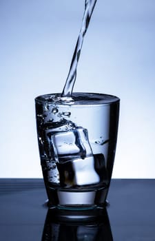 The image of pouring drinking water, into a glass, that makes one feel refreshed on blurred white background, Splashing water, Sparkling water