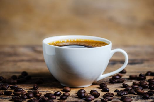A cup of coffee with coffee bean on wooden background dark tone dtyle