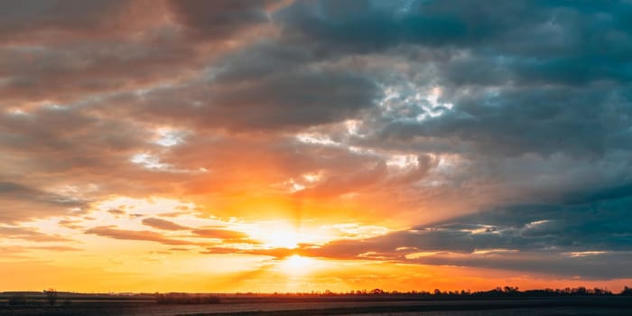 Sun Shine During Sunset Above Empty Spring Countryside Rural Soil Landscape. Field Under Sunny Spring Sky. Agricultural Landscape With Copy Space. Panorama.
