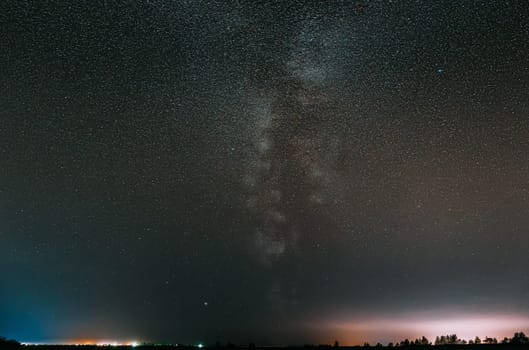 Milky Way Galaxy In Night Starry Sky With Glowing Stars Above Countryside Landscape.