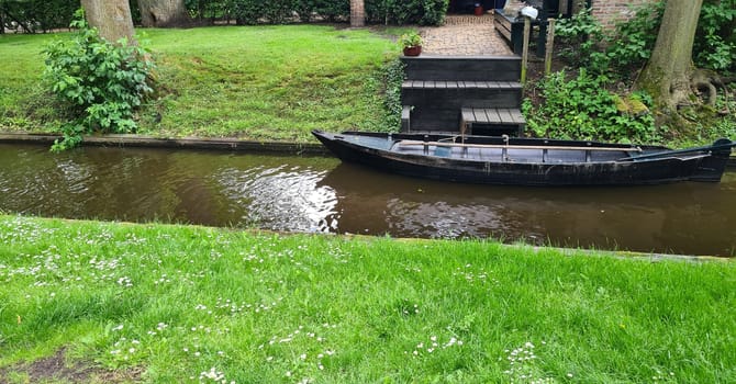 Tranquil view of the village of Giethoorn in the Netherlands, with beautiful country houses, water canals and colorful flowers