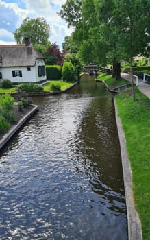Tranquil view of the village of Giethoorn in the Netherlands, with beautiful country houses, water canals and colorful flowers