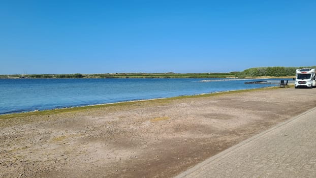 View over the sea from the dune over North Sea and canal in Ouddorp, Zeeland province, The Netherlands. Outdoor scene of coast in Europe nature.