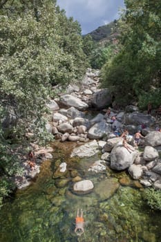 Guijo de Sta Barbara - August 25th, 2022: Visitors enjoying La Maquina Natural swimming pool, Guijo de Santa Barbara, Spain. Crystal-clear waters spot in the heart of La Vera County, Caceres, Extremadura