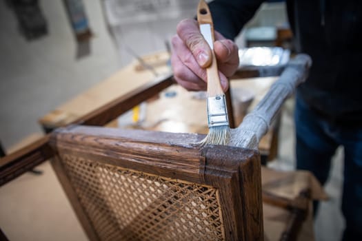 a man restores a chain by painting it with a plaster