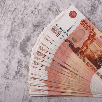 Russian money banknotes of five thousand rubles, background, banknotes are arranged in a fan on a gray background. Layout, mockup.