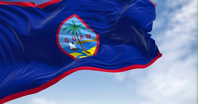 Flag of Guam waving in the wind on a clear day. Guam is an organized, unincorporated territory of the United States in the Micronesia subregion of the western Pacific Ocean