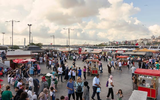 Istanbul, Turkey - August 30, 2022: Crowds of local citizens at Eminonu Plaza during the Victory Day holiday with background of Istanbul city view