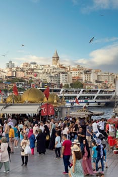 Istanbul, Turkey - August 30, 2022: Crowds of local citizens at Eminonu Piazza during the Victory Day holiday with background of Istanbul city view including Galata Tower