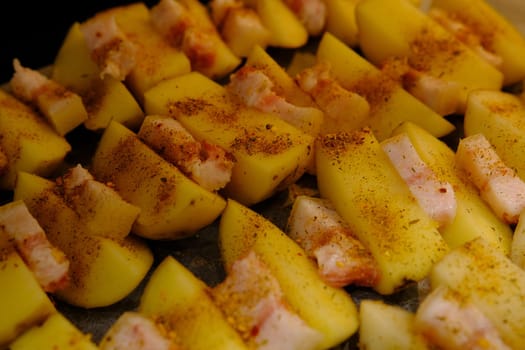Delicious Potato Bratkartoffeln With Bacon close up in the plate on ready to bake.