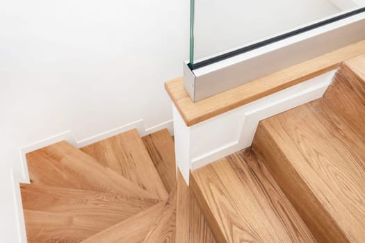 Modern residential wooden stairs. Wood staircase inside contemporary white modern house.