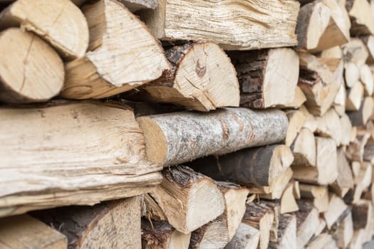 Full Frame Pile of Firewood Background Weathered Cracked Wood Texture.