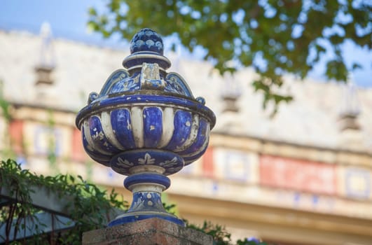 Colored ceramic top vase close to Palace of San Telmo, Seville, Andalusia, Spain. Brick wall top