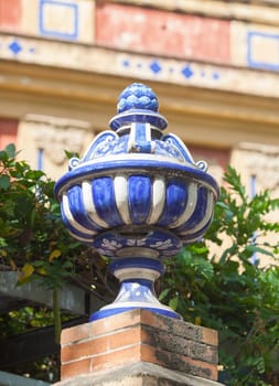 Colored ceramic top vase close to Palace of San Telmo, Seville, Andalusia, Spain. Brick wall top