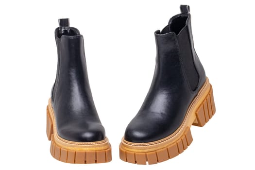Ladies Chelsea boots. Close-up of a pair womens black leather chelsea boots with high heels isolated on a white background. Macro. Fashion advertisment shoes.