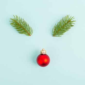 Face of a reindeer with a red bauble nose and fir antlers, merry christmas greeting card