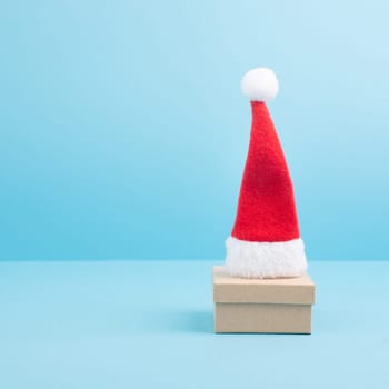 Red Santa Claus hat on a gift box, christmas and new year greeting card with copy space
