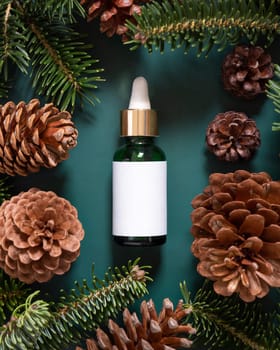 Green Pipette Dropper Bottles with blank label near fir branches and pine cones top view. Brand packaging mockup. Skincare beauty product, cream or serum. Natural cosmetics concept