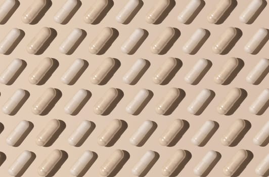 Capsules on light beige top view, hard shadows, creative pattern. Preventive medicine and healthcare, taking dietary supplements and vitamins. Assorted pharmaceutical medicine capsules