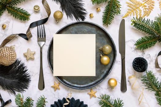 Black and golden Table setting with ornaments and fir tree branches top view, square card mockup. Christmas or New Year atmospheric composition on marble table, copy space.