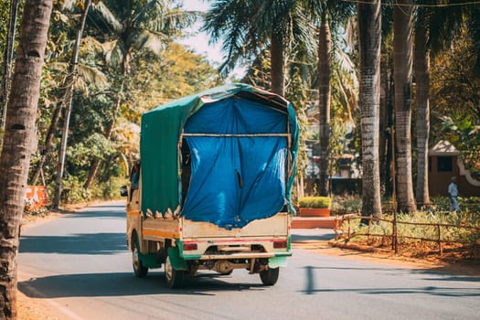 Goa, India. Small Truck Is Moving Along City Street. Back View.