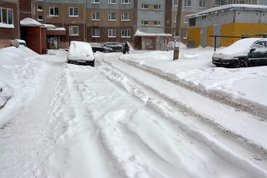 In the yard of the house there is not cleaned snow after a blizzard. High quality photo