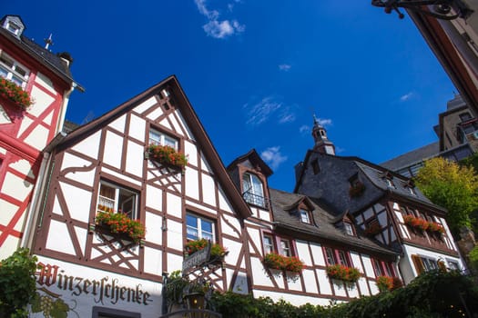 BEILSTEIN, GERMANY - SEPTEMBER 03 2022: historic village along the river Moselle with old half-timbered houses and the ruins of castle Metternich on top of the hills