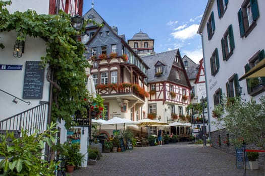 BEILSTEIN, GERMANY - SEPTEMBER 03 2022: historic village along the river Moselle with old half-timbered houses and the ruins of castle Metternich on top of the hills