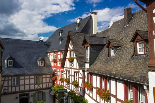 BEILSTEIN, GERMANY - SEPTEMBER 03 2022: historic village along the river Moselle with old half-timbered houses and the ruins of castle Metternich on top of the hills