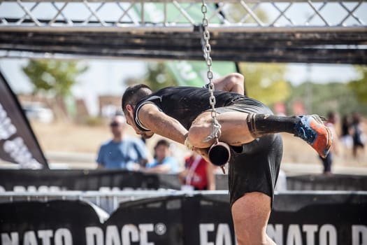 Merida, Spain - Sept 11th, 2022: FarinatoRace Merida 2022. Toughest obstacle course in the world. Climbing over a hanging bar