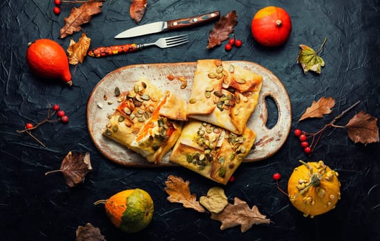 Sweet pumpkin roasted in pita bread.Autumn dessert on retro wooden surface