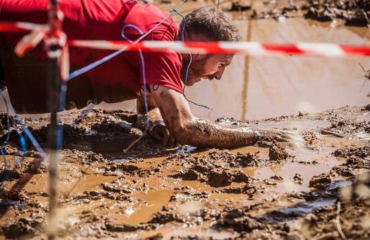 Merida, Spain - Sept 11th, 2022: FarinatoRace Merida 2022. Toughest obstacle course in the world. Crawling under wire