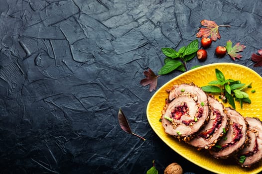 Appetizing roll roast with autumn plum and nuts.Pork porchetta.Copy space