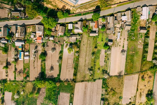 Russia. Aerial View Of Small Town, Village Cityscape Skyline In Summer Day. Residential District, Houses And Vegetable Garden Beds In Bird's-eye View.