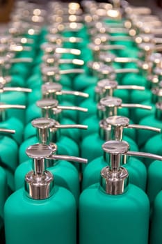 Selective focus on the front part of a group of green spray bottles in a market.