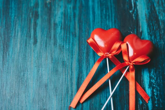 Valentine's day design with two red love hearts on blue texture wooden background with copyspace. Retro filter.