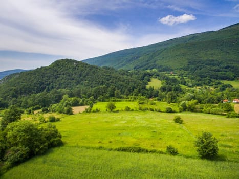 Aerial view of mountain green landscape. Highland hills and meadows form above.
