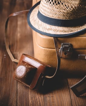 Vintage case, hipster hat,  and retro camera on wooden background still life.. Summer holiday vacation and adventure traveling concept.