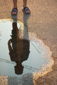 silhouette of a kid on a small pond at street