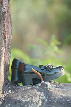Young girl shoe over vintage stone wall, lost child concept