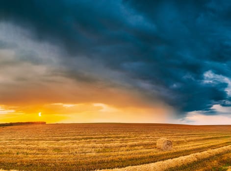 Aerial View Of Sunset Bright Sky Above Summer Hay Field Landscape In Evening. Haystack, Hay Roll in Sunrise Sunset time.