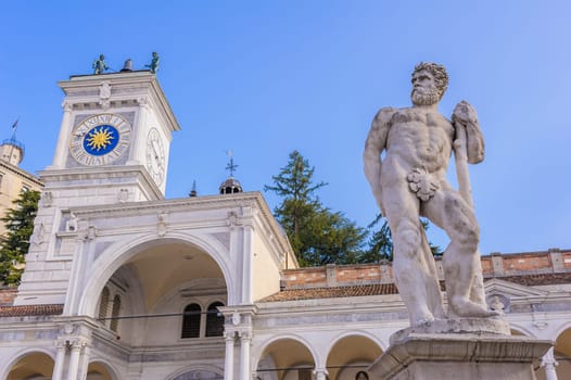 Statue of Caco, the clock tower in the background. Udine Friuli Italy