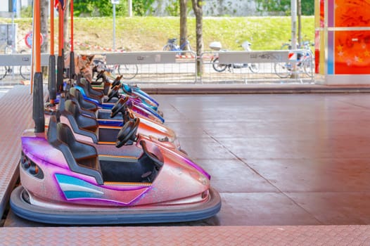Colorful bumper cars for children in line.