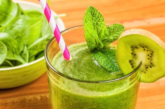Green smoothie with a slice of kiwi and fresh mint leaves
