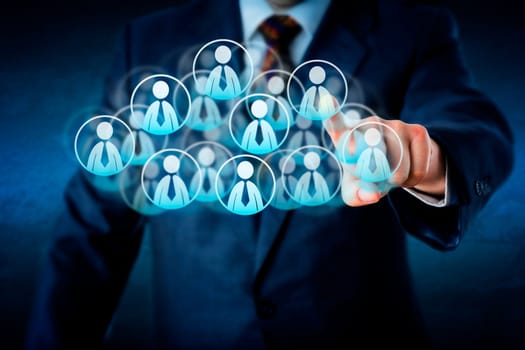 Torso of a manager in blue business suit selecting white color worker icons in a virtual cloud shaped of many office worker symbols. Technology metaphor combining smart computing and human resources.