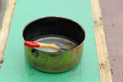 a paint brush in a pot with wood stain. brushes for painting wood