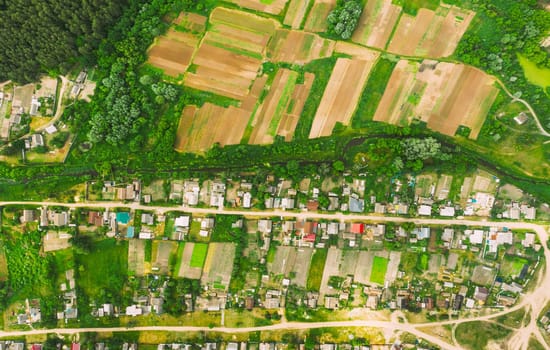 Aerial View Of Vegetable Gardens In Small Town Or Village. Skyline In Summer Evening. Village Garden Beds In Bird's-eye View.