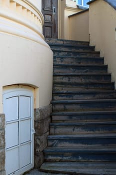 Entrance staircase of an old building made of light stone. Ancient city architecture.
