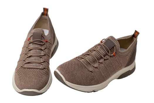 Closeup of a pair of modern brown sneakers or sports shoes isolated on a white background. Elegant and trendy mans shoes. Macro.